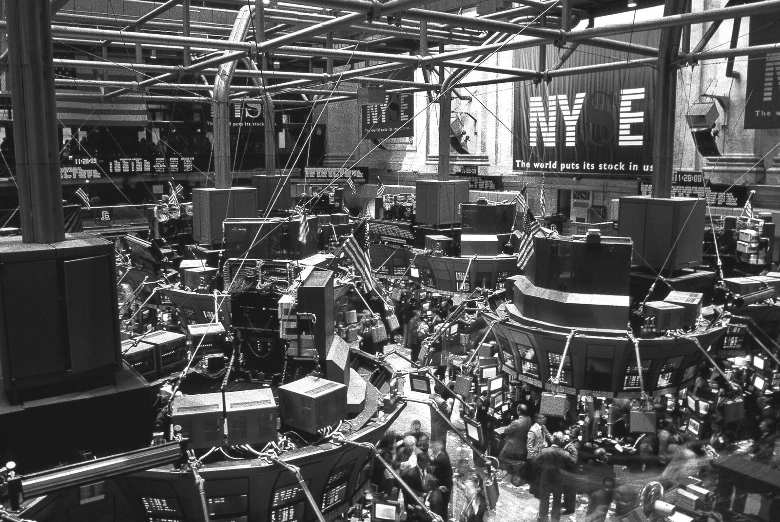 The crowded trading floor of the New York Stock Exchange, with brokers working beneath tall market-data screens